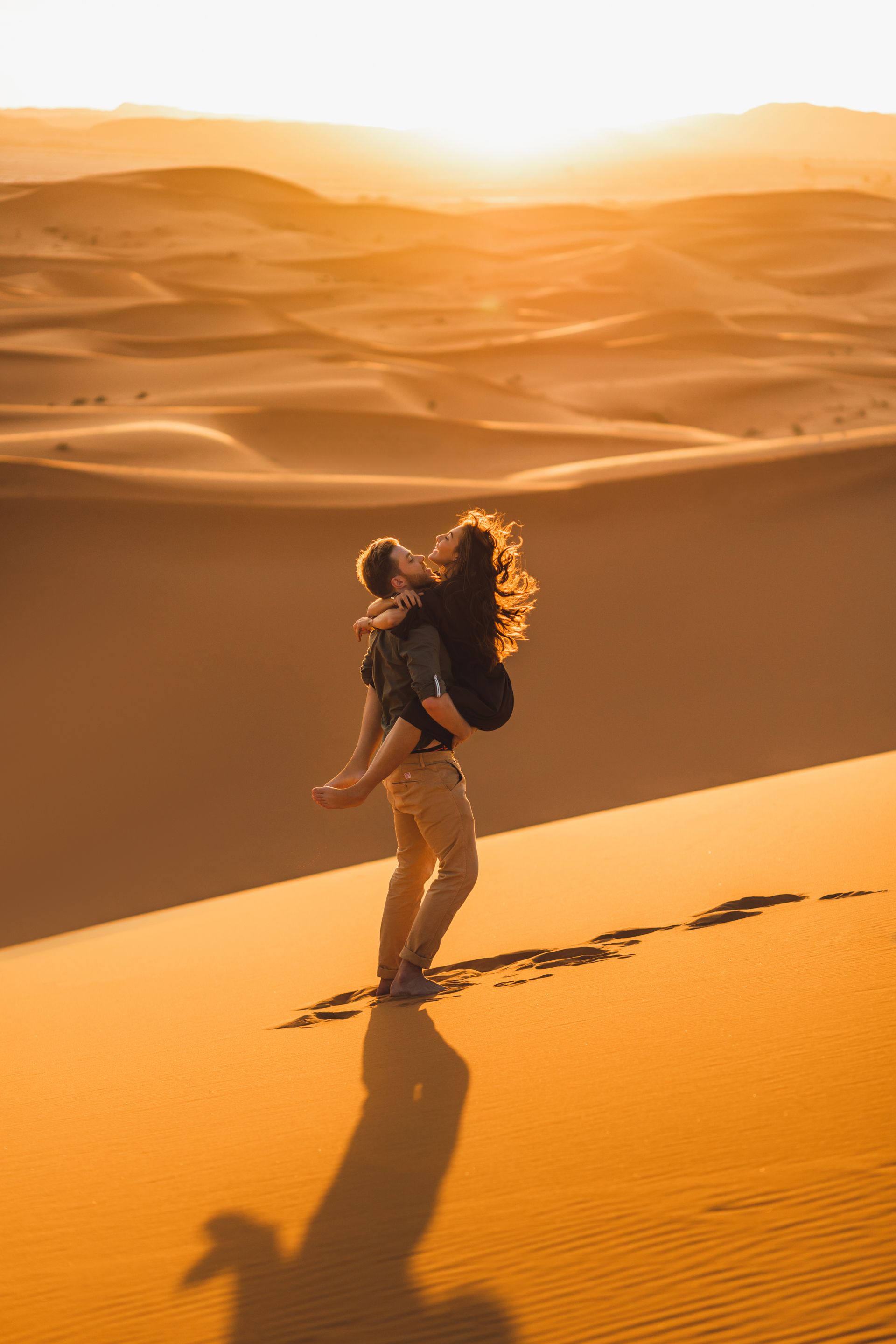 Couple walking through desert at golden hour